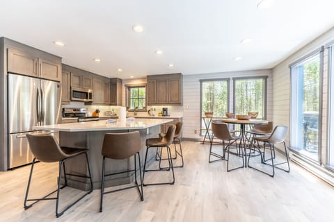 The full-sized kitchen featuring modern updates throughout and breakfast table with surrounding windows offering gorgeous views.