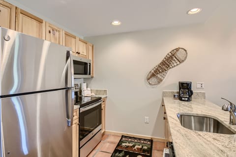 Kitchen with natural stone countertops and SS appliances