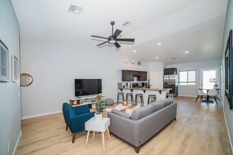 Inviting living room with open concept and 65" TV. Netflix & Disney+ included.