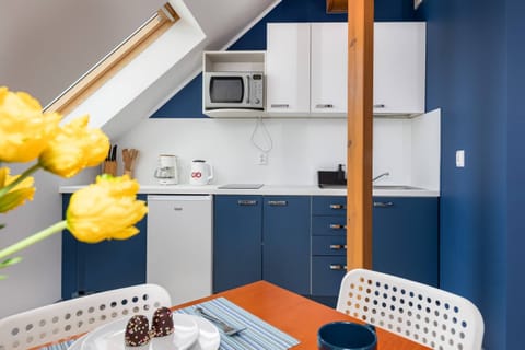 A compact kitchen with a blue and white color scheme, blending style and practicality.
