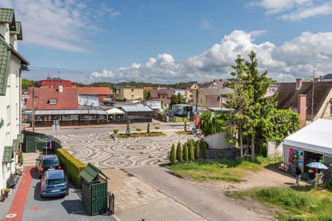 An exterior view of the picturesque neighborhood with traditional architecture and greenery.
