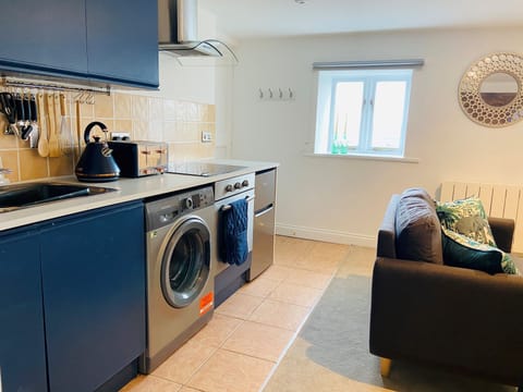 The fully equipped kitchen with washing machine, microwave, oven and hob.
