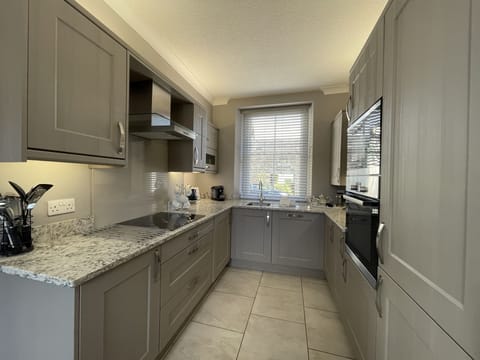 Beautiful kitchen with Bosch integrated appliances including touch induction hob, Tassimo coffee machine and a washer/ dryer