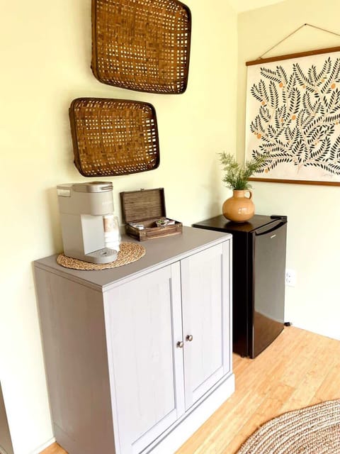 Corner with the mini-fridge, Keurig coffee maker (coffee provided), and microwave is neatly hidden away in the gray cabinet. View of the king-size bed, looking at the bathroom door, and looking into the second room.