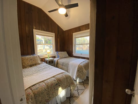 Twin beds in bedroom 1 with ceiling fan.