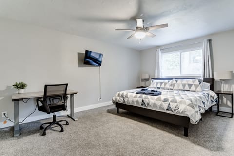 Master bedroom with king memory foam mattress, desk, ceiling fan and smart TV