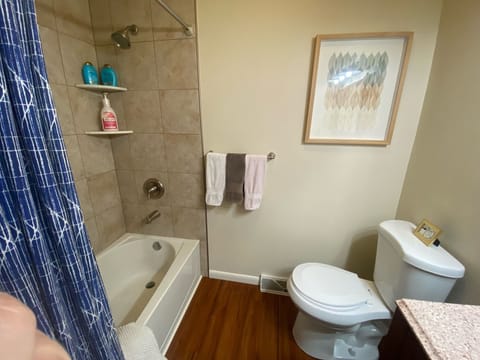 Shared bathroom in hallway with bathtub 