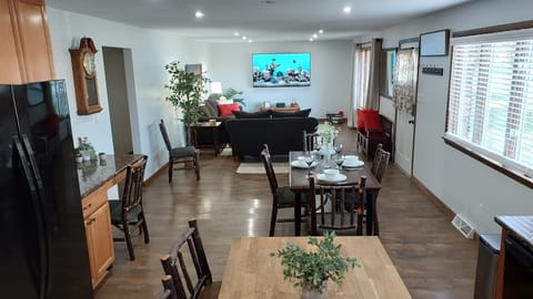 View of the dining area and living room with 75 in. smart TV.