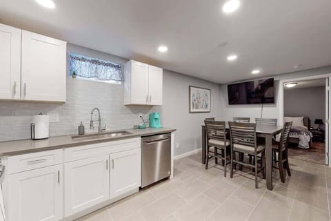 White cabinets and updated kitchen with stainless appliances make this basement feel spacious and bright.  Equipped with cooking amenities, Keurig Coffee maker with coffee pods provided. Dining table with 6 chairs and smart TV