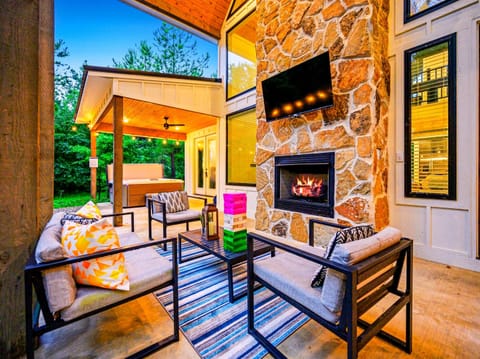- Cozy up around the stone fireplace with smart TV and colorful seating under the trees - Outdoor games like giant Jenga and soft pillows add fun and comfort - Steps from the covered hot tub, this space is ideal for evening relaxation