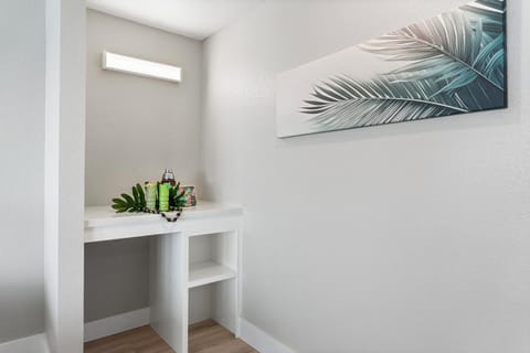 Bright vanity nook for getting ready, accented with a modern tropical art piece.