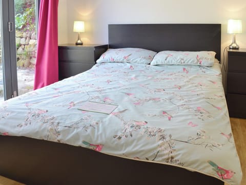 Relaxing double bedroom with bi-fold doors and en-suite shower room | Kataluma, Praa Sands, near Penzance