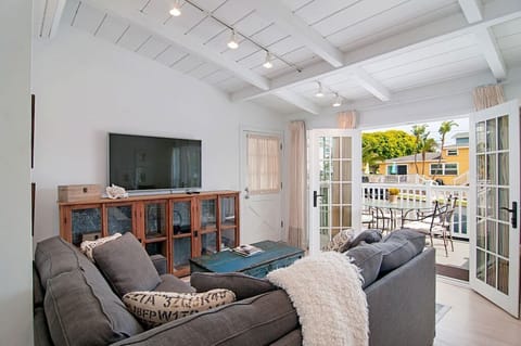 View ofliving space with large flat screen TV and outside deck.