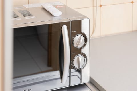 A close-up of the kitchen appliances, focusing on a modern microwave. The kitchen combines practicality with clean design.