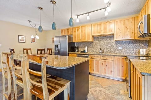 The gorgeous kitchen with granite countertops, stainless steel appliances, stylish backsplash, pendant lighting and a large island with bar seating for three will delight the chef in your group.