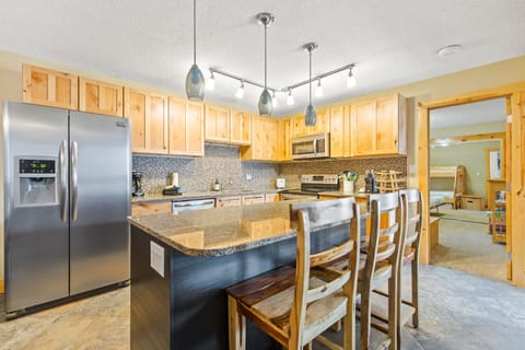 The gorgeous kitchen with granite countertops, stainless steel appliances, stylish backsplash, pendant lighting and a large island with bar seating for three will delight the chef in your group.