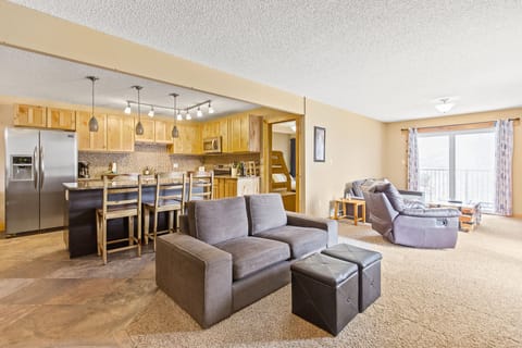 The open-concept living/kitchen/dining area allows you to easily move between the kitchen, with its fabulous tile work and stainless steel appliances, and the living room with its cozy furnishings, TV and fireplace.