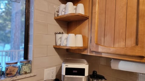 Coffee corner with drip coffee maker, French press, and electric kettle.