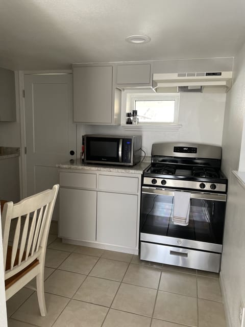 Kitchen with stainless steel appliances. Stove, microwave, fridge, and keurig