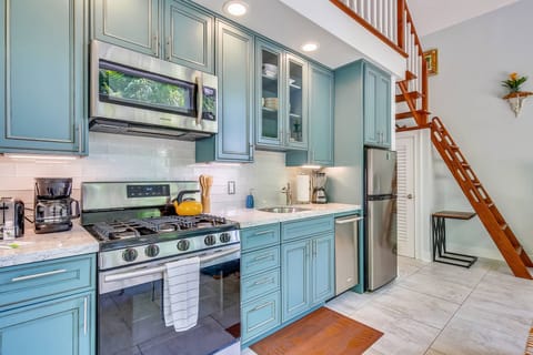 Kitchen features modern appliances and beautiful blue finishes.