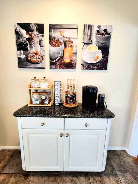 Coffee bar has a Keurig, coffee pods, creamer, sugar, flavor syrups, and tea.