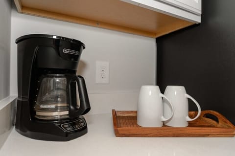 Coffee lovers, celebrate! A coffee maker and all the essentials are ready for your morning brew. Enjoy your favorite cup in a cozy spot, whether you're starting your day or winding down.