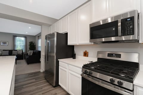 This elegant kitchen features stainless steel appliances, sleek cabinetry, and stunning countertops. The spacious layout, with a large island, is perfect for meal prep, casual dining, and hosting guests in a sophisticated, functional space.