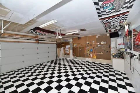 It took 25 hours to hand paint this race-themed b&w checkered flag garage floor.