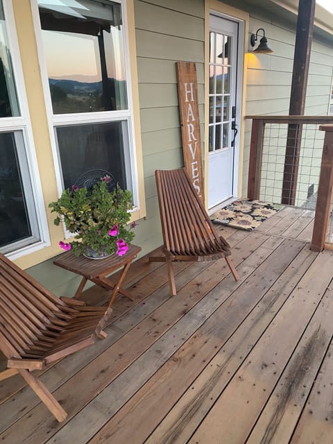 Front deck with two chairs and a bench that coverts to a picnic table, seats 6