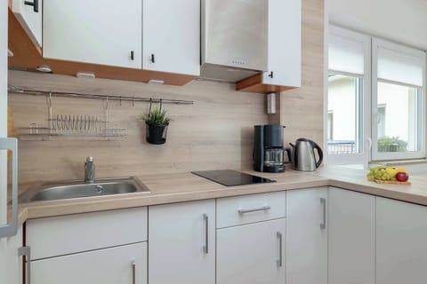 Close-up of the kitchen counter with a coffee maker, kettle, and a few decorations on the shelves.