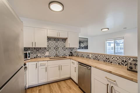 Stainless steel appliances, butcherblock countertops, new cabinets, and a decorative backsplash bring a modern touch to this kitchen