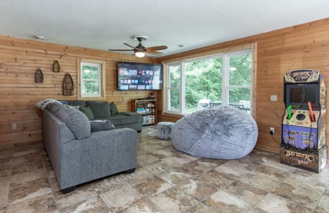 Open family area with a huge Lovesac, arcade, games & toys, and a smart TV