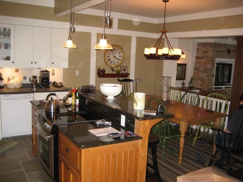 Kitchen and dining area with harvest table, 8 chairs and 3 counter stools