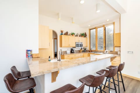 Open kitchen with breakfast bar seating for six