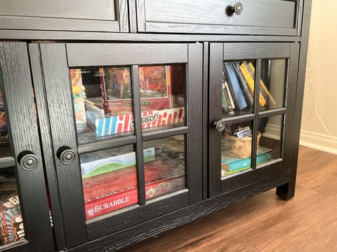 The console table contains board games, puzzles, playing cards, and books
