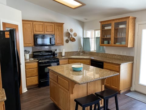 The kitchen is fully stocked with pots, pans, baking dishes, and cookware.