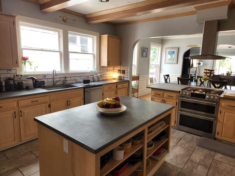 Massive center island, tile floors, fridge to left.