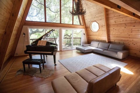 Large open concept living room with baby grand piano