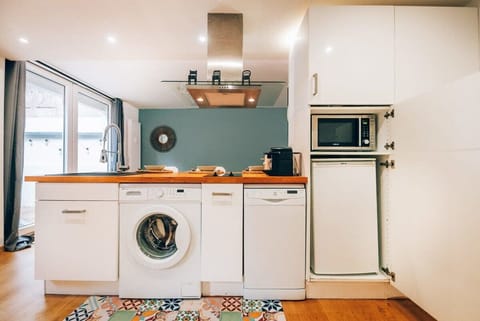 Well-appointed kitchen with modern amenities, including a washing machine and microwave, ensuring convenience for longer stays.