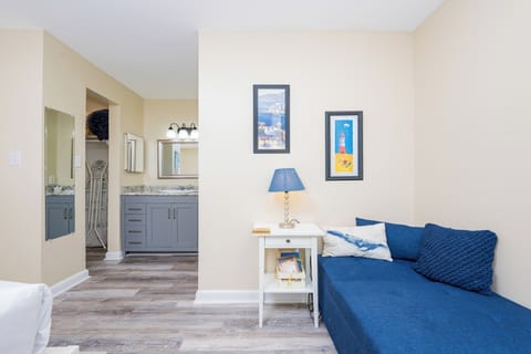 This cozy space in the master features a blue seating area, stylish decor, and a well-appointed bathroom with modern fixtures