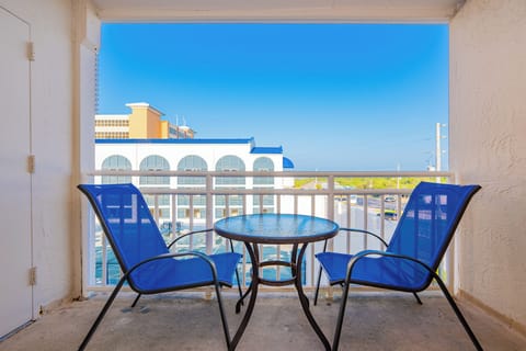 This balcony features blue chairs and a table, offering a refreshing view of the area and a perfect spot to relax