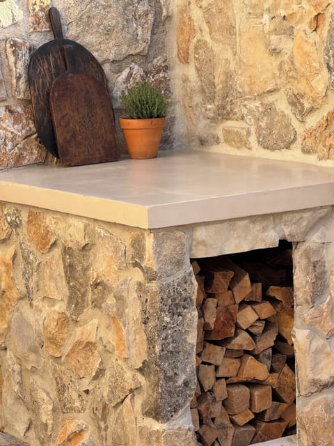 Wood-burning pizza oven stocked with wood