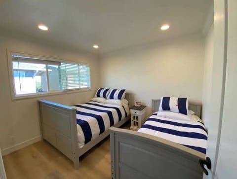 One full size bed and one twin size bed with google home display and a closet