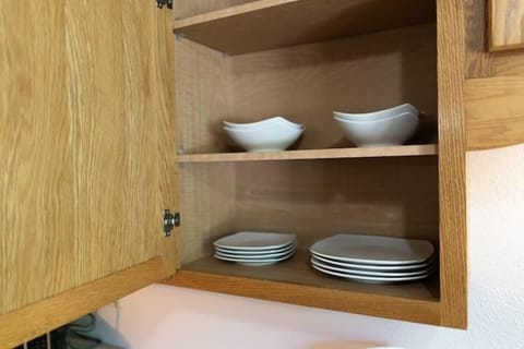 Plates and bowels can be found in the cabinet to the left of the kitchen sink