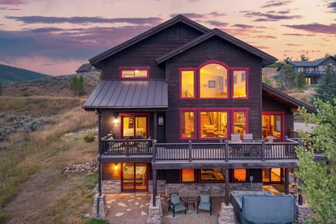 Back of home showing out door space, hot tub and size of home