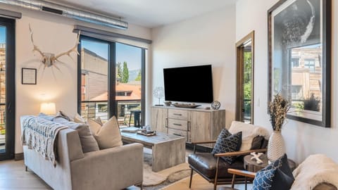 Open concept living room with luxury queen sofa sleeper, HDTV with streaming capabilities   cable, wrap around balcony, mountain views, and cozy mountain modern decor.