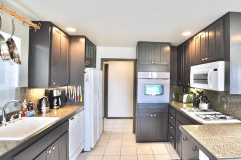 Full kitchen with gas range, electric oven, coffee maker, dishwasher, and refrigerator/freezer.