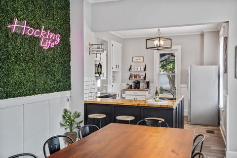 Kitchen entryway with Hocking Hills neon sign, bar seating, and coffee bar.