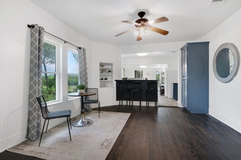 The table and chairs is to the left of the breakfast bar