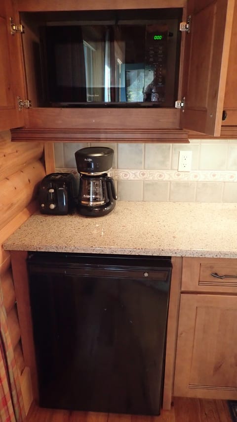 Toaster, coffee pot, refrigerator and microwave in the kitchen area.